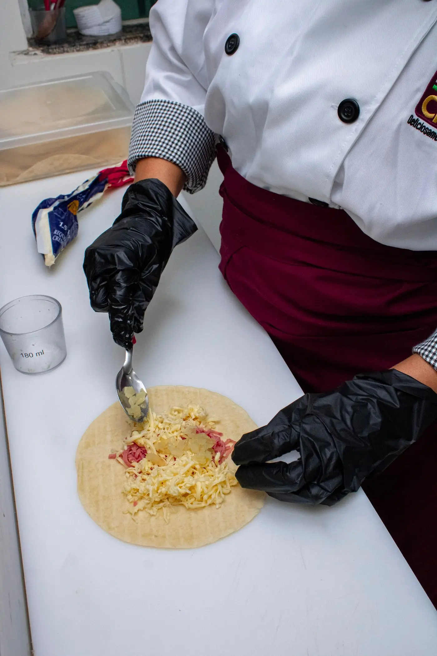 A chef preparing a wrap by hand at a small work surface