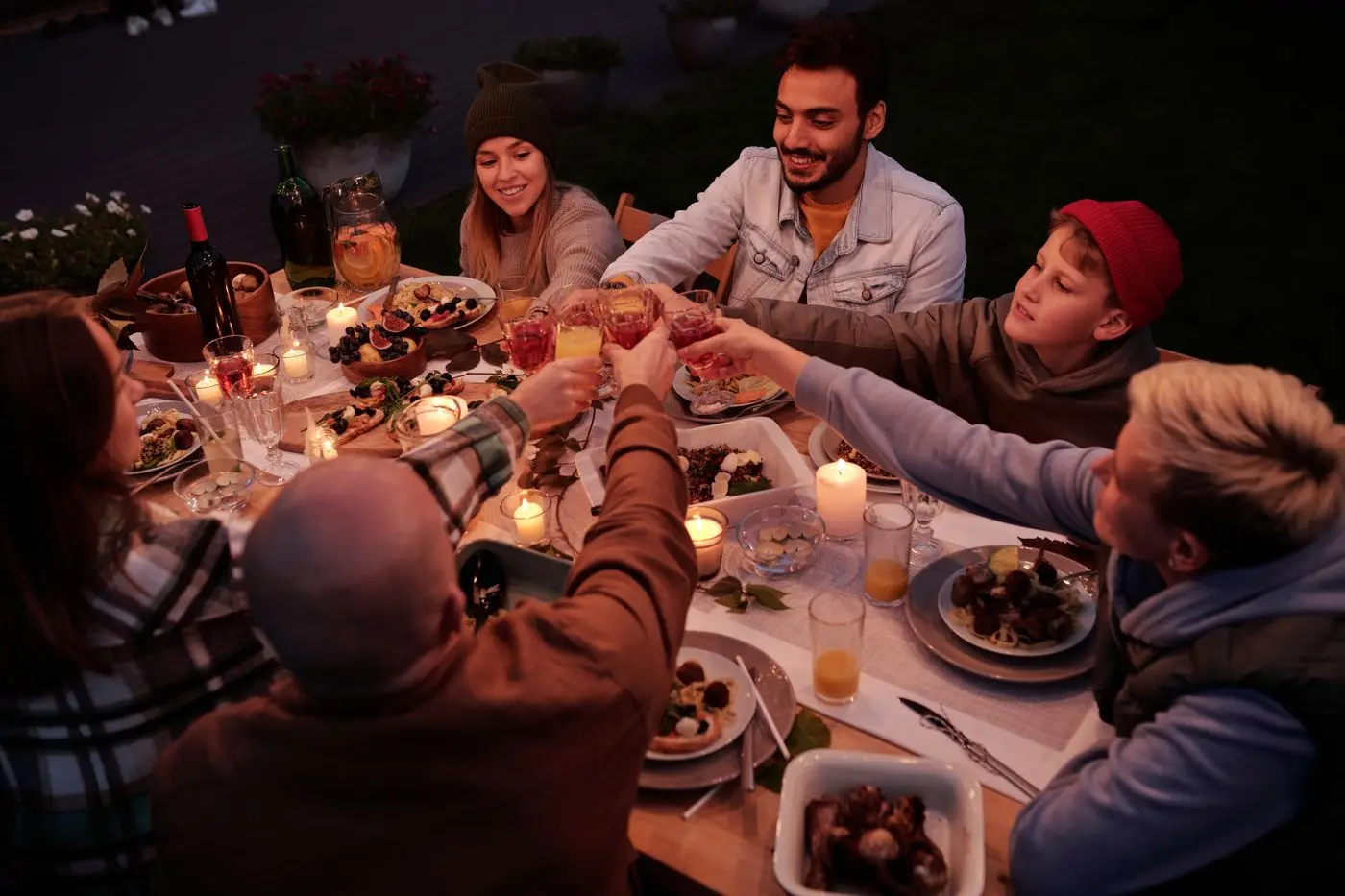 Guests sharing a toast around a candlelit garden dinner